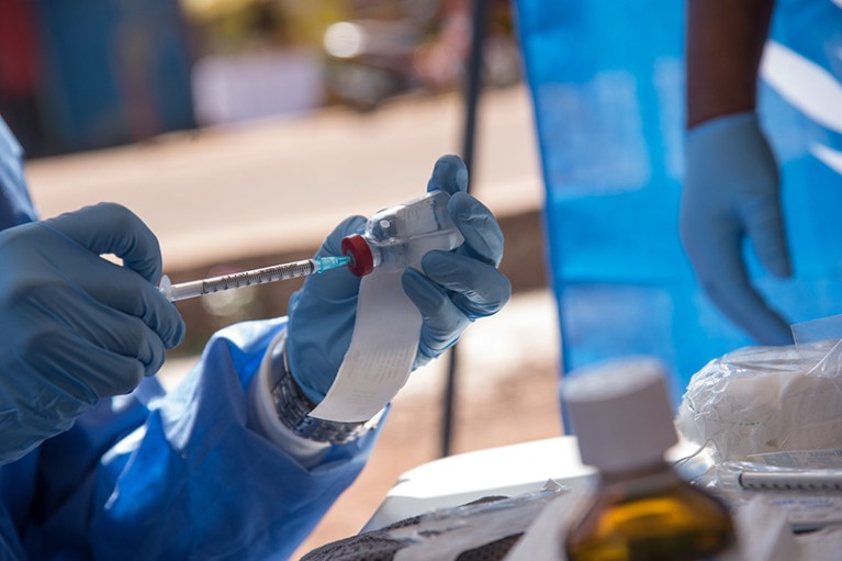 Closeup of the hands of a WHO nurse filling an injection with an ebola vaccine in Mbandaka, DRC, in May.