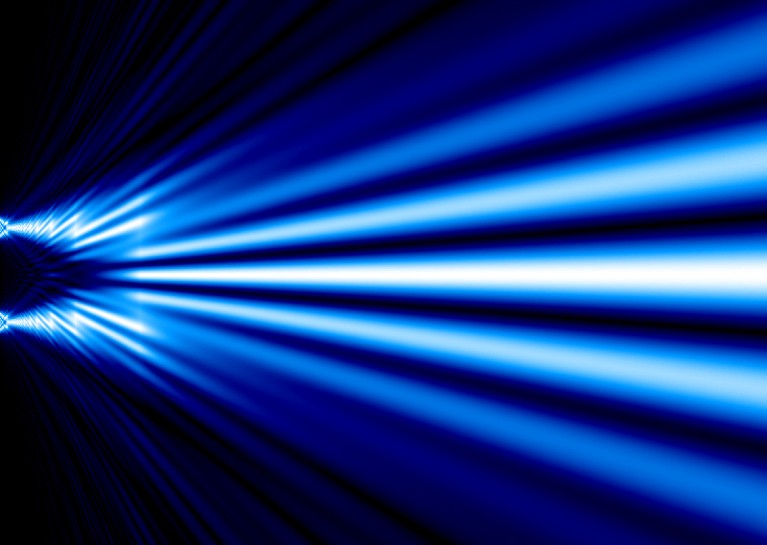 Blue light splitting into wave like interference pattern during a double slit experiment.