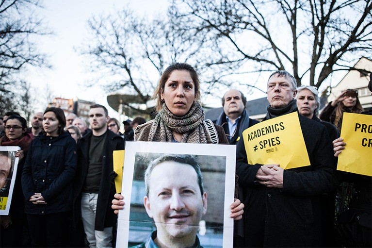 People protesting with photos of Ahmadreza Djalali nd and Hamid Babaei in Brussels