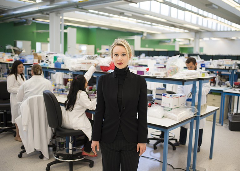 A woman dressed all in black, in a laboratory.