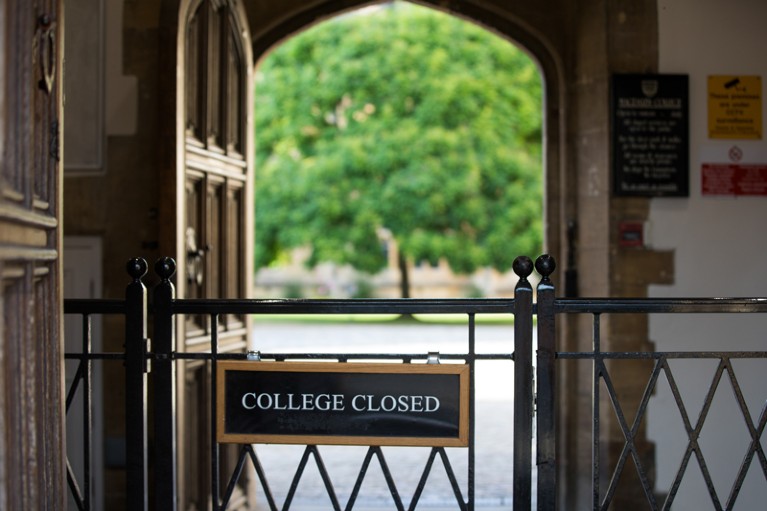 A gate displaying a closed sign stands at the entrance to Magdalen College
