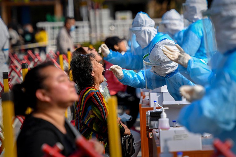 A health worker takes a swab from a resident.