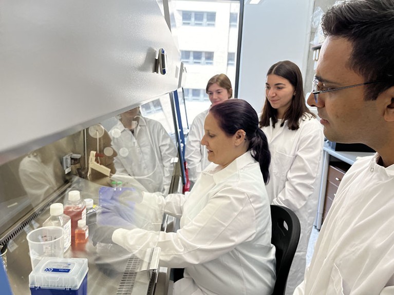 Stephanie Seidlits is seated in the lab, with lab members Mollie Harrison, Talia Sanazzaro, and Niraj Babu standing behind her