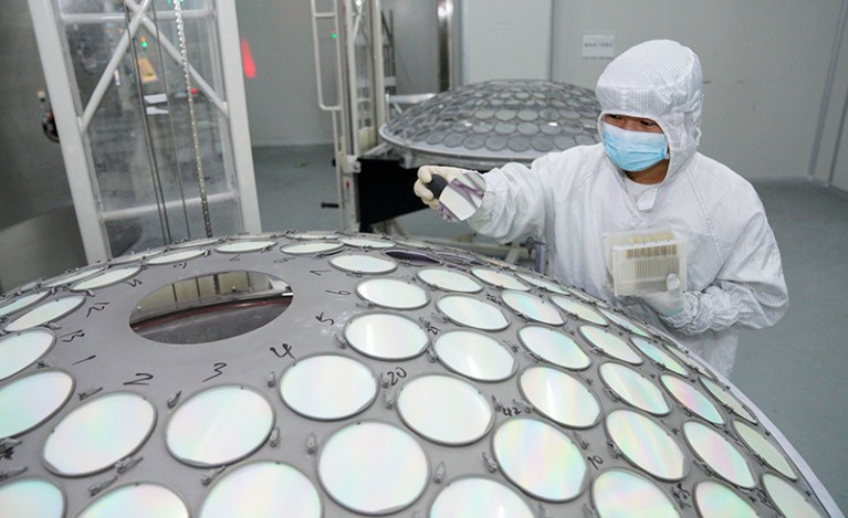 A worker in a dust-proof suit controls an LED epitaxy chip production line at a semiconductor workshop in Nanchang