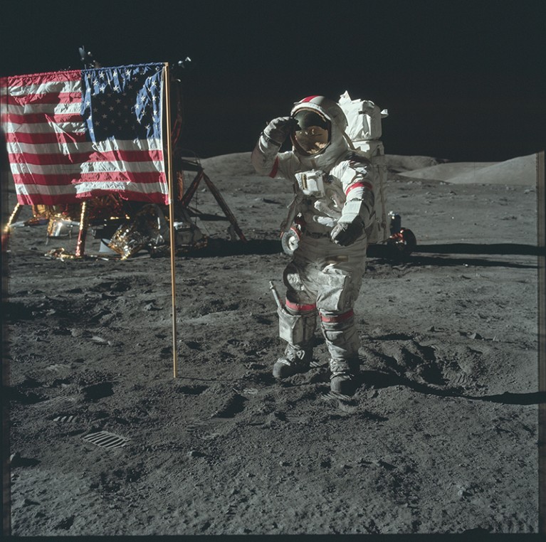 The Apollo 17 mission with a man in a space suit on the lunar surface saluting the American flag planted to his side.