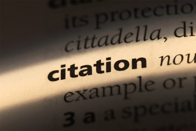 Citation word definition in a dictionary highlighted with light shining across the word on the page