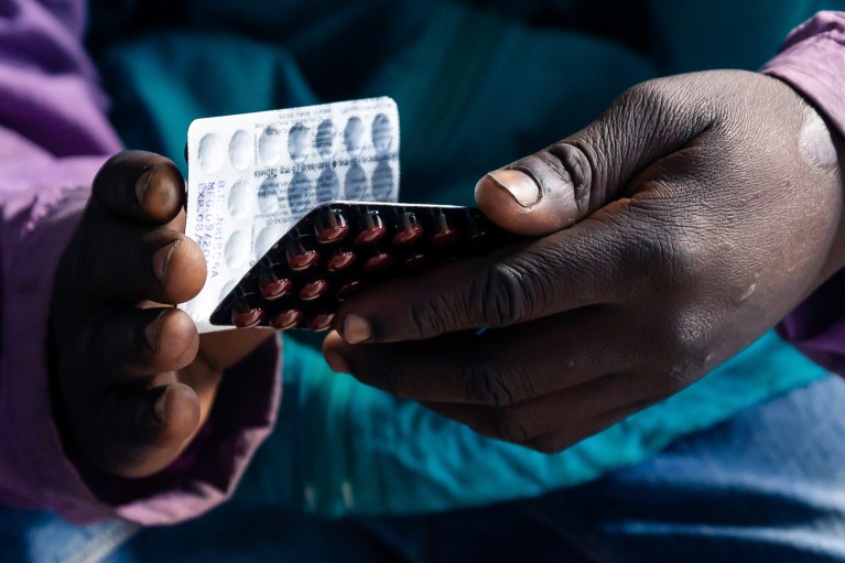 Close up of a HIV positive TB patient holding a packet of tablets received as part of his treatment