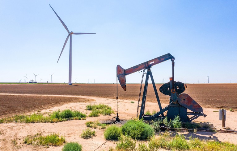 Windmill from Mesquite Creek Wind O&M with an oil derrick, Lamesa, TX, USA.
