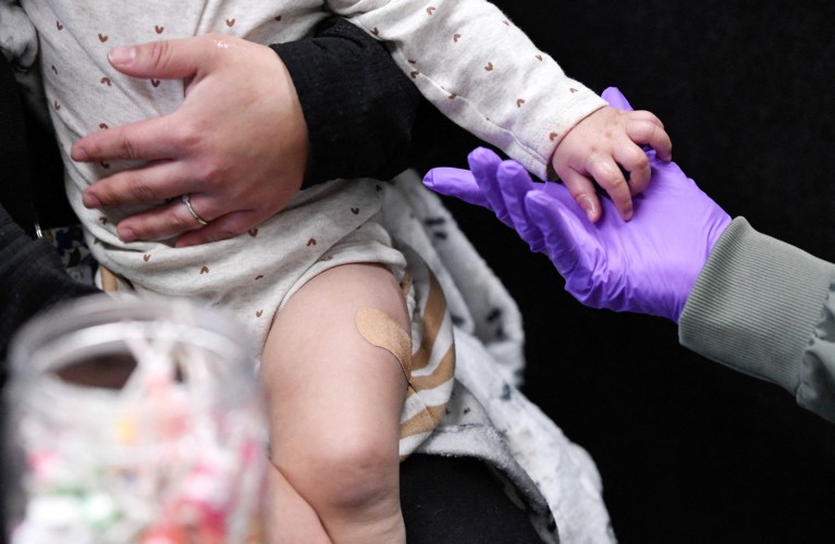 Close-up of an unidentified baby with a plaster on its leg after just receiving a vaccine