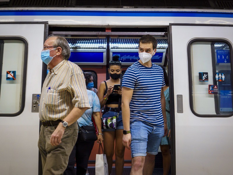 Passengers wear protective face masks as they alight a Metro train in Madrid.
