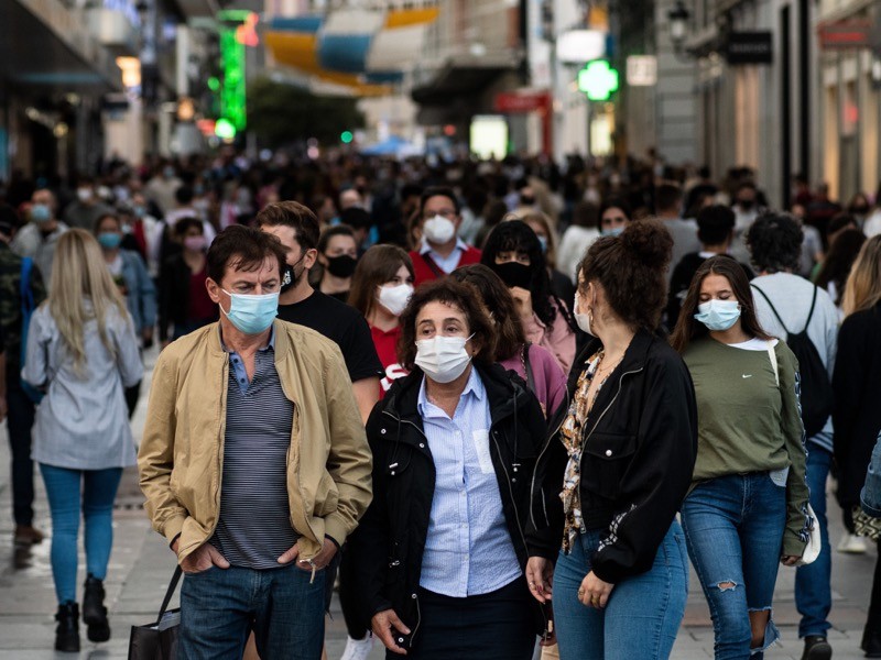 Preciados Street in downtown Madrid crowded with people wearing protective face masks.