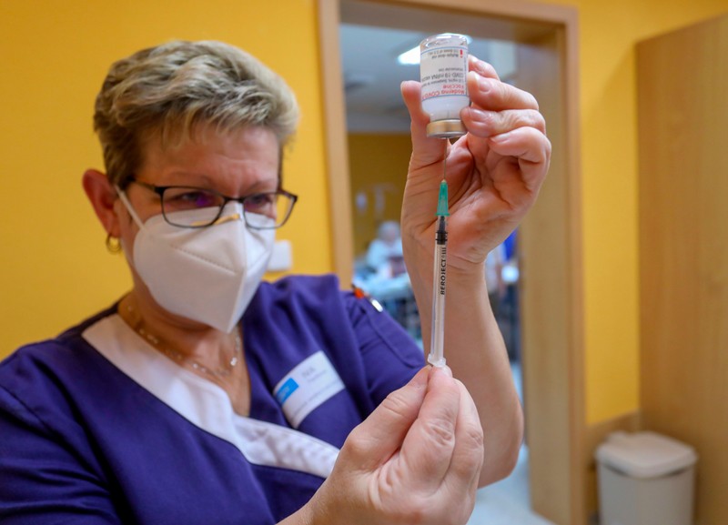 A doctor prepares a Moderna vaccine.