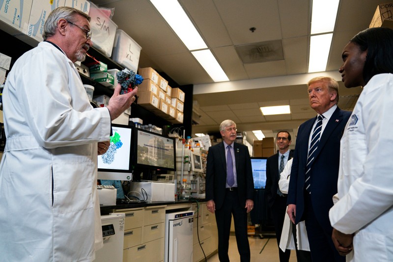 Barney Graham holds a molecular model as he speaks to Donal Trump and others during a tour of his lab