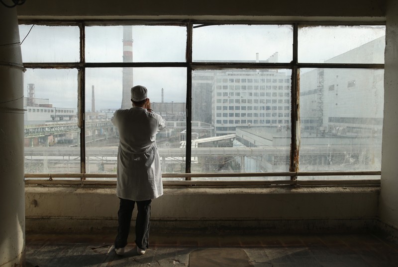 A visitor takes a photo through a window of the defunct Chernobyl nuclear facilities