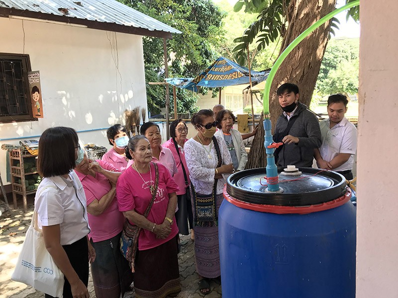 Photo of Pimchai Chaiyen (left) teaching villagers in Nan how to turn food waste into cooking gas.