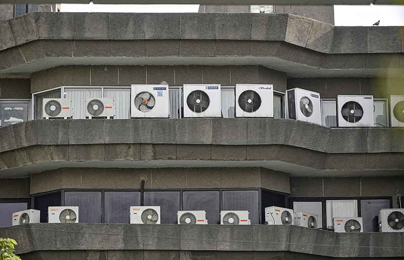 Multiple air conditioners are installed outside a concrete building in New Delhi, India, in 2020.