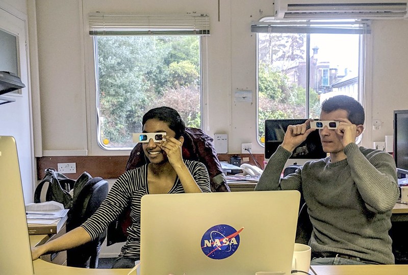 Divya Persaud and a colleague viewing 3D imagery of Mars on computers while wearing red/blue (anaglyph) glasses.