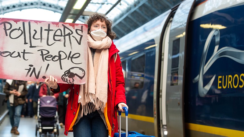 COP26 traveller with a sign catching the Eurostar to COP26.