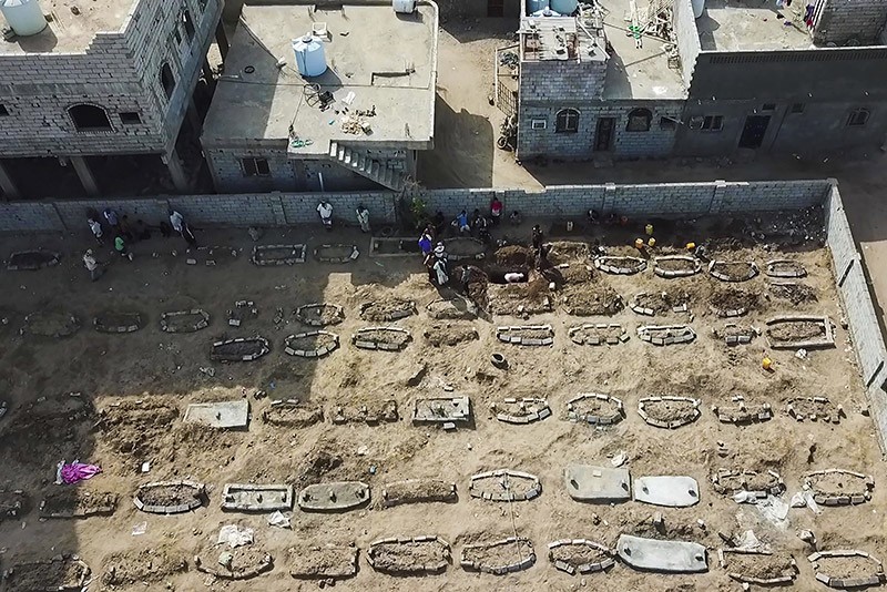 Aerial view of grave diggers burying bodies at Radwan Cemetery in Aden, Yemen.