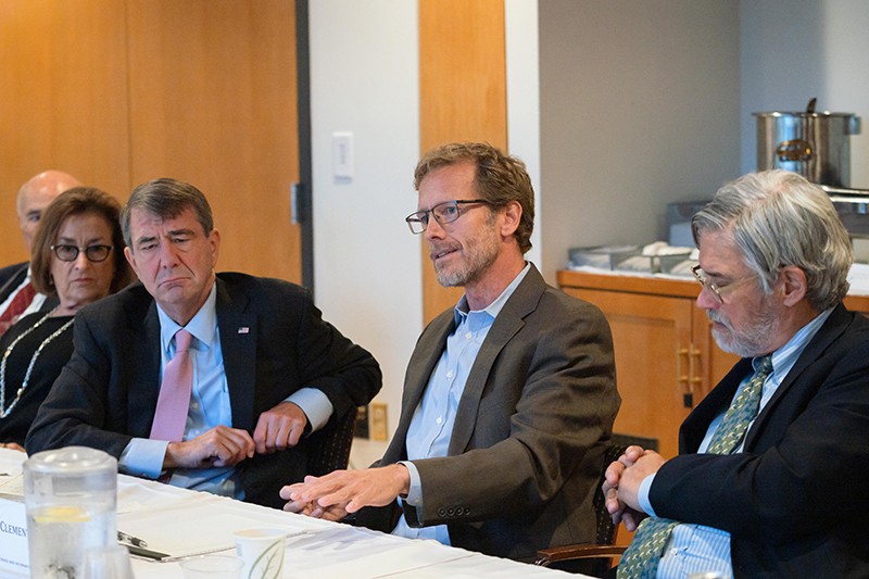 Joel Clement, second from right, at a table with other people in a meeting.