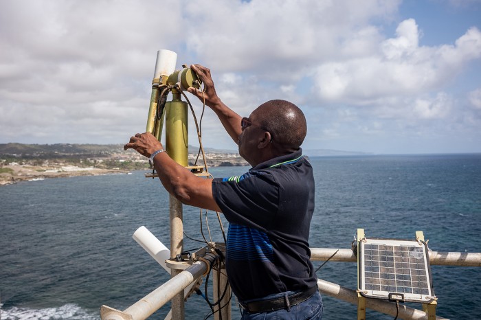 Edmund Blades works at the Barbados Dust Observatory platform, checking exterior instruments on the top.