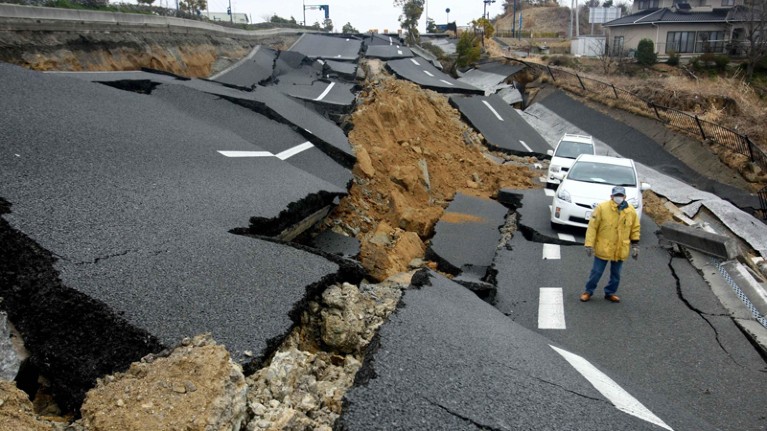 Man standing on a road damaged by an earthquake