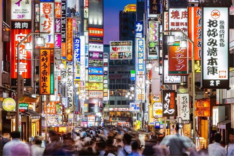 A street in Tokyo with many lit signs