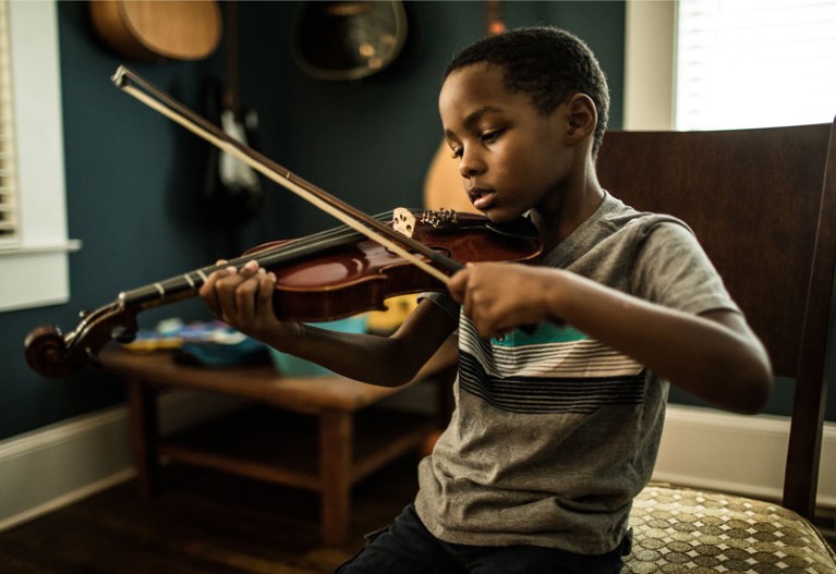 Young boy (6 yrs) practicing violin.
