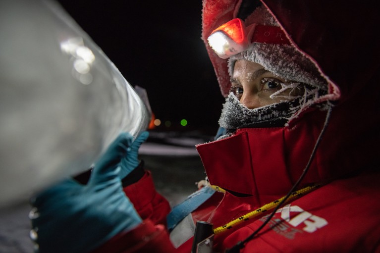 Maria Josefa Verdugo in polar outfit holds up an ice core