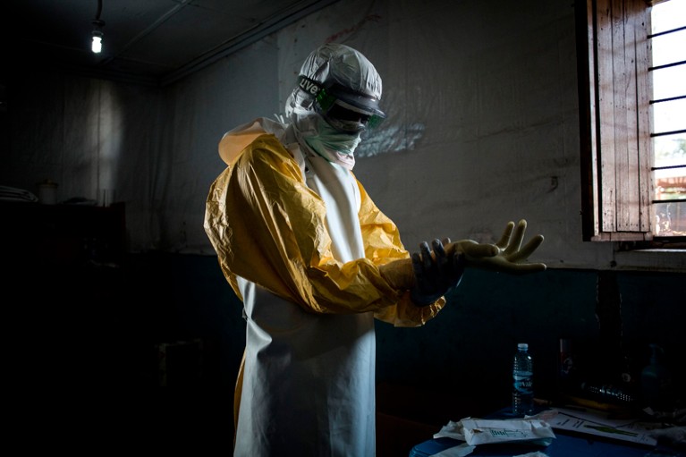 A health worker puts on his personal protective equipment