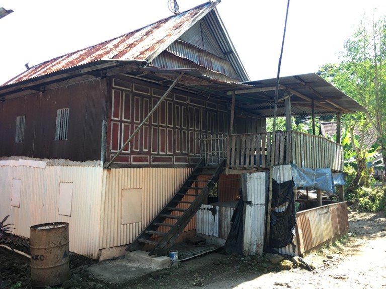 A house made of pieces of corrugated metal and wooden railings.