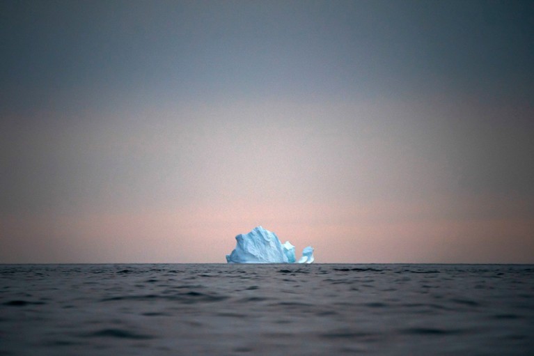 A single Iceberg floats as the sun sets near Kulusuk, Greenland