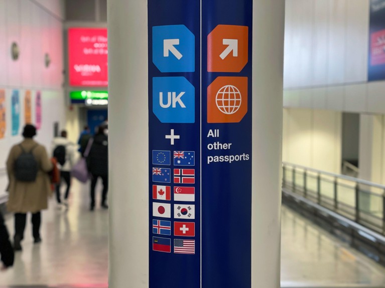 Close-up photo of a sign pointing towards passport control in an airport