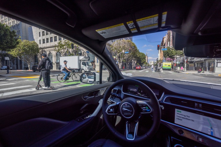 A view inside a Waymo robotaxi Jaguar I-PACE driverless car as it drives down a street