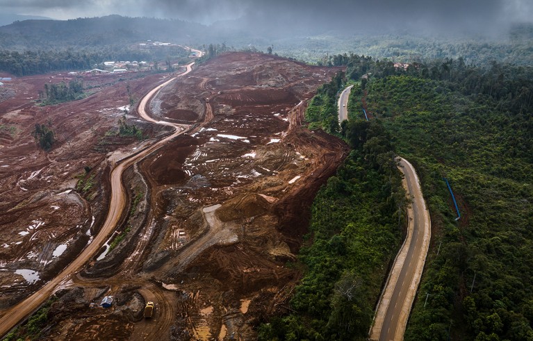 Aerial view of a nickel mine operated near a forest with road passing through in Central Sulawesi, Indonesia.
