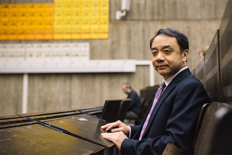 Professor Wang Yifang was sitting in a conference room of the Ruhr-Universitat Bochum. Periodic paintings are visible on the walls behind him