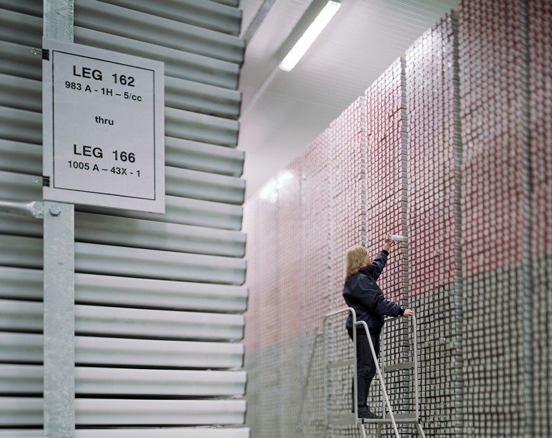 A researcher takes a sediment core in a cold store