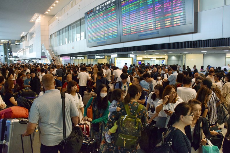 Passengers wait in the Arrivals Hall of Narita International Airport