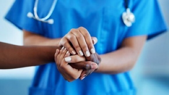 Cancer Disparities image - shows a medical professional clasping hands with another.