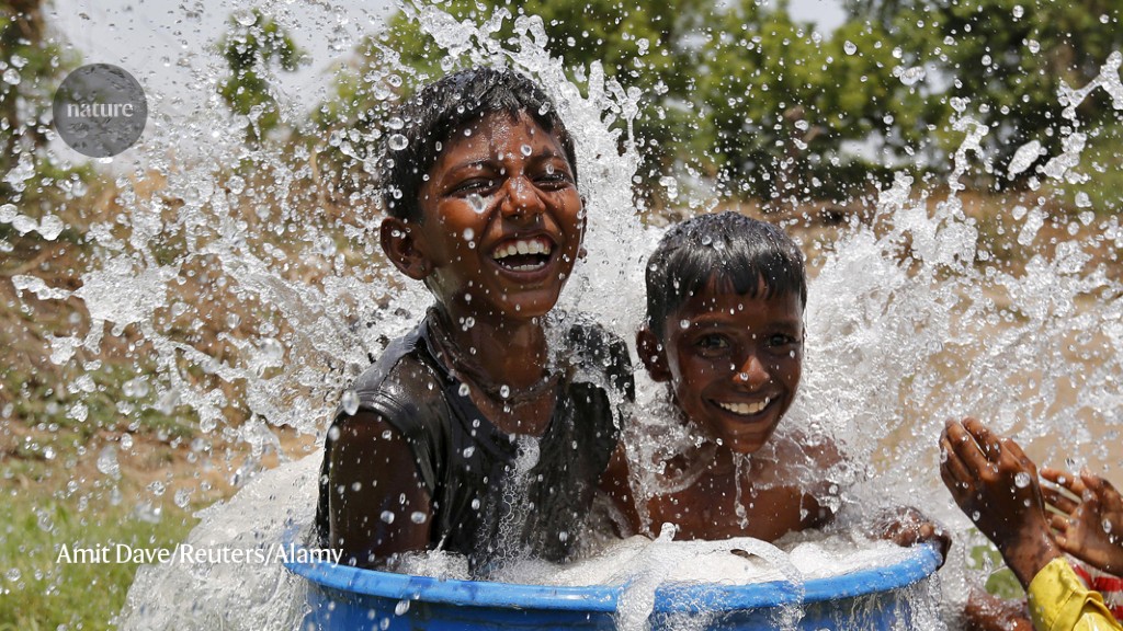 Boys cooling themselves on a hot day in Ahmedabad, India, where a heatwave action plan is helping to save lives. Credit: Amit Dave/Reuters/Alamy  Last