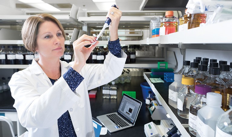 Immunologist Shannon Turley works in a lab with a pipette