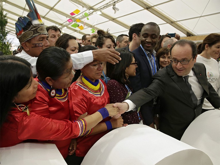 French President Francois Hollande shakes hands with visitors at COP21 in Paris.