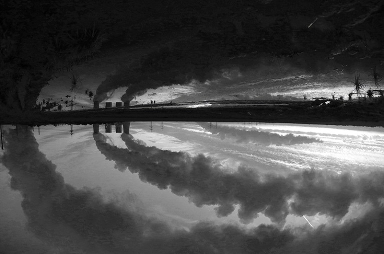 Coal power plant of German utility RWE Power is reflected in a puddle