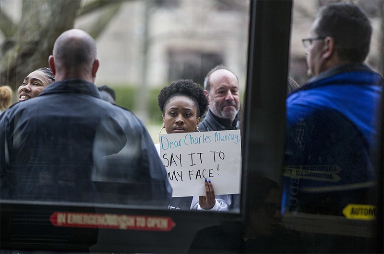 Student holds up sign during protest against Charles Murray at University of Notre Dame in Indiana USA