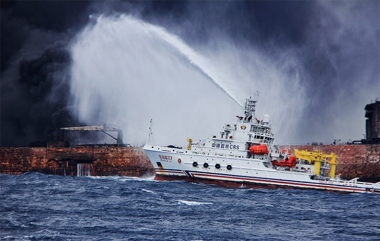 Rescuers spray foam to extinguish flames on the stricken oil tanker Sanchi