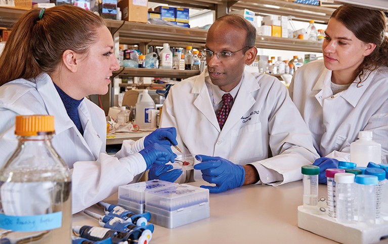 Kiran Musunuru and two members of his team look at a sample of liver in the lab.