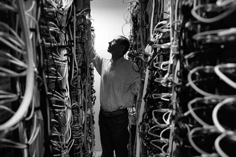 A man checks the wires of a data storage device
