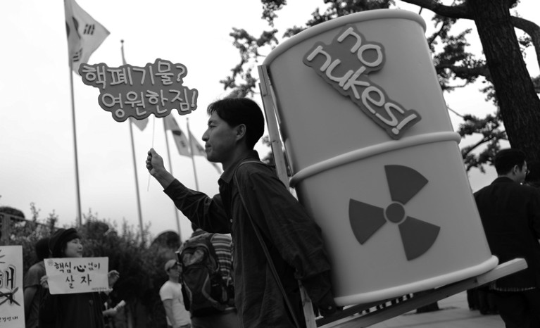 Protester carrying nuclear waste drum in anti-nuclear power protest
