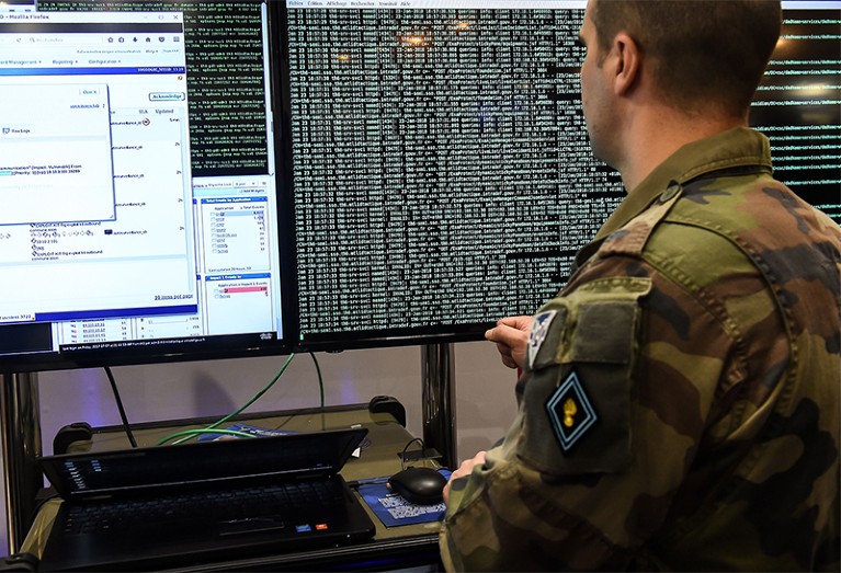 A military cyberdefence specialist stares at a computer screen