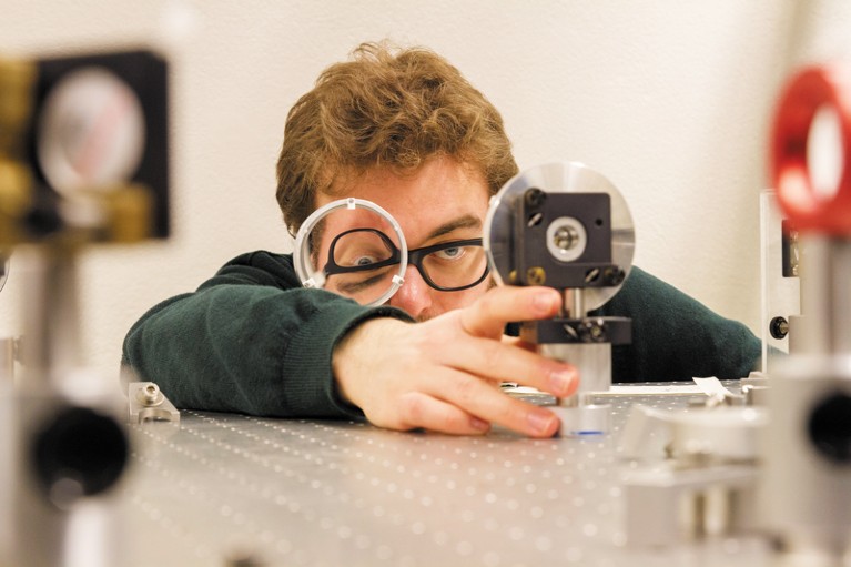 Researcher aligns spherical silver mirrors on the laser table